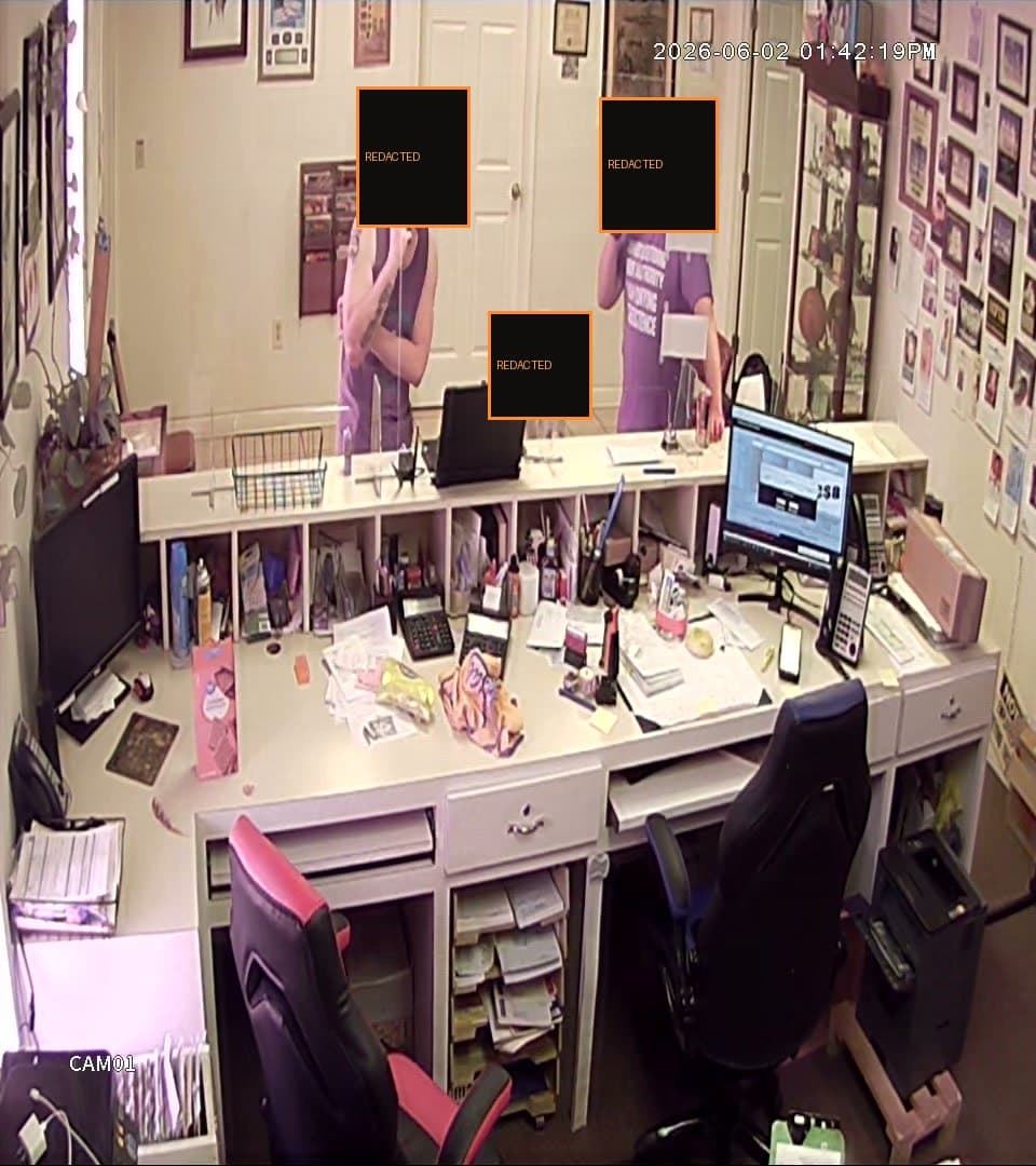 Redacted still from an unauthenticated interior camera feed captured during the assessment; faces obscured.